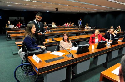 A Deputada Mara Gabrilli, Terceira Secretária da Câmara dos Deputados, discussa. Ao lado, na bancada pode-se ver os Deputados Carmen Zanotto, Luizianne Lins e Aelton Freitas.